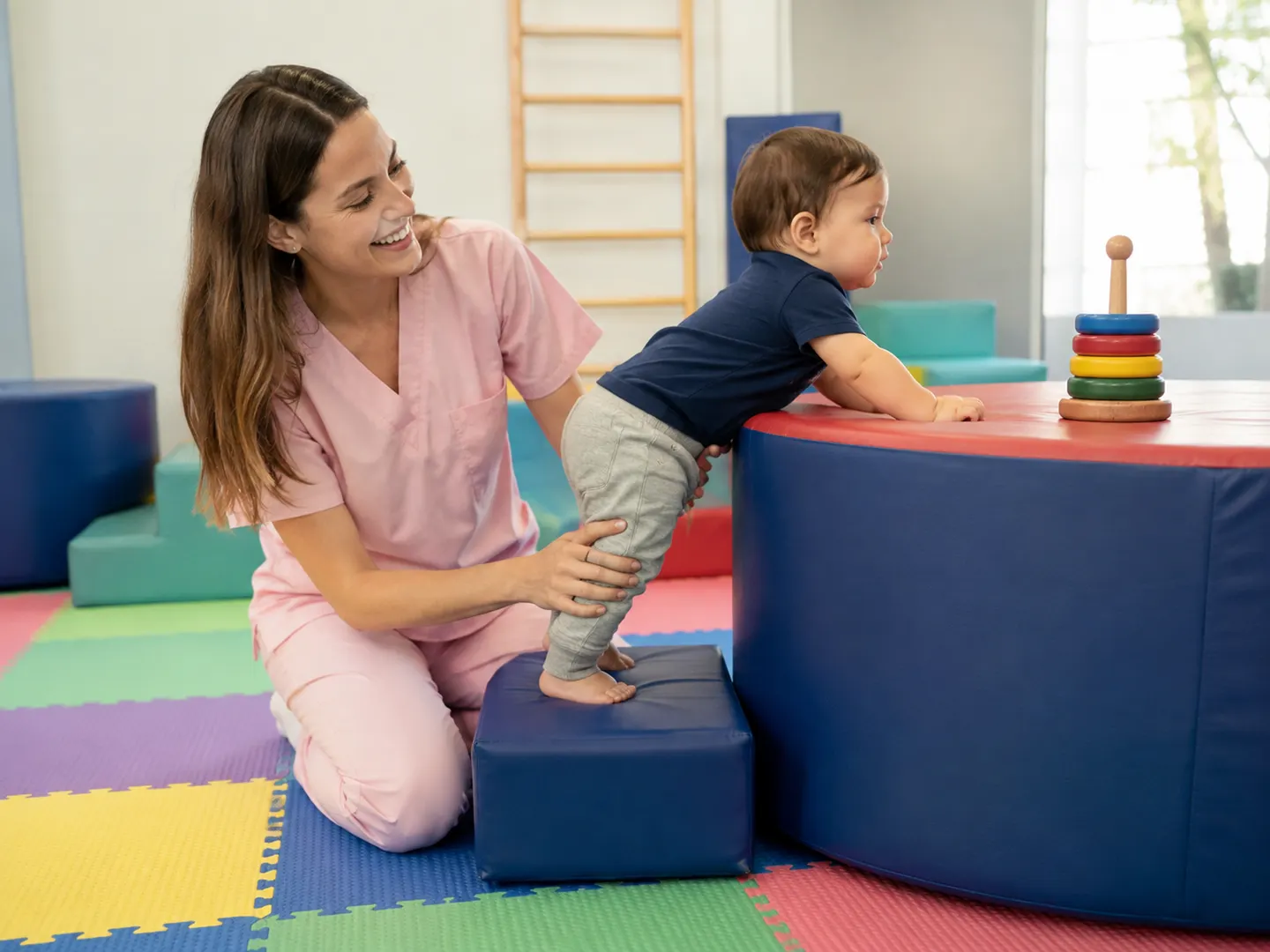 Especialista acompaña a un bebé en una actividad de estimulación motora